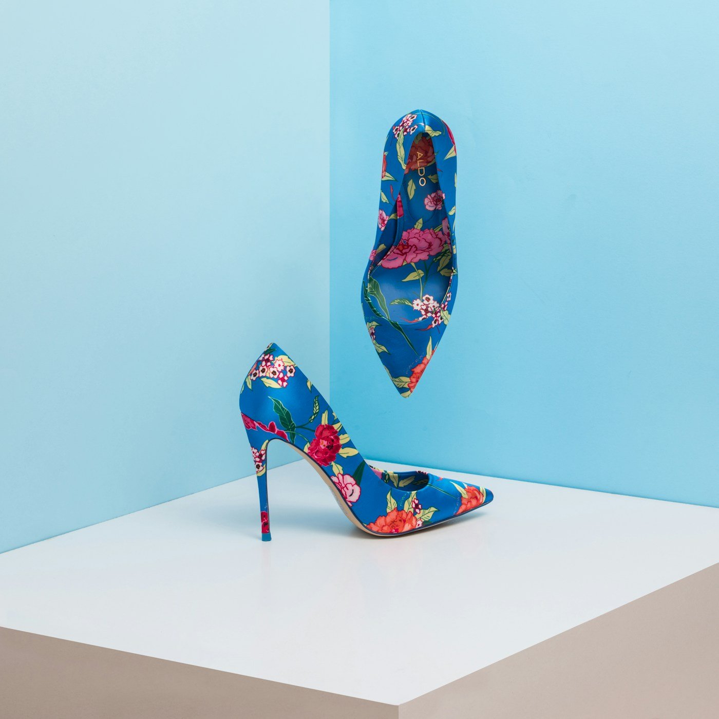 Scarpe con tacco e fantasia floreale su sfondo azzurro